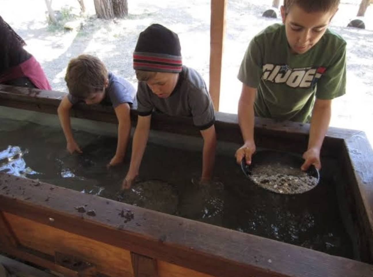 Kids panning for gold at a trough
