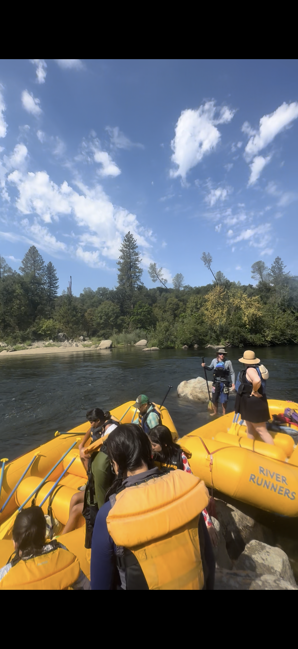 Families in life vests loading rafts on a calm stretch of the American River