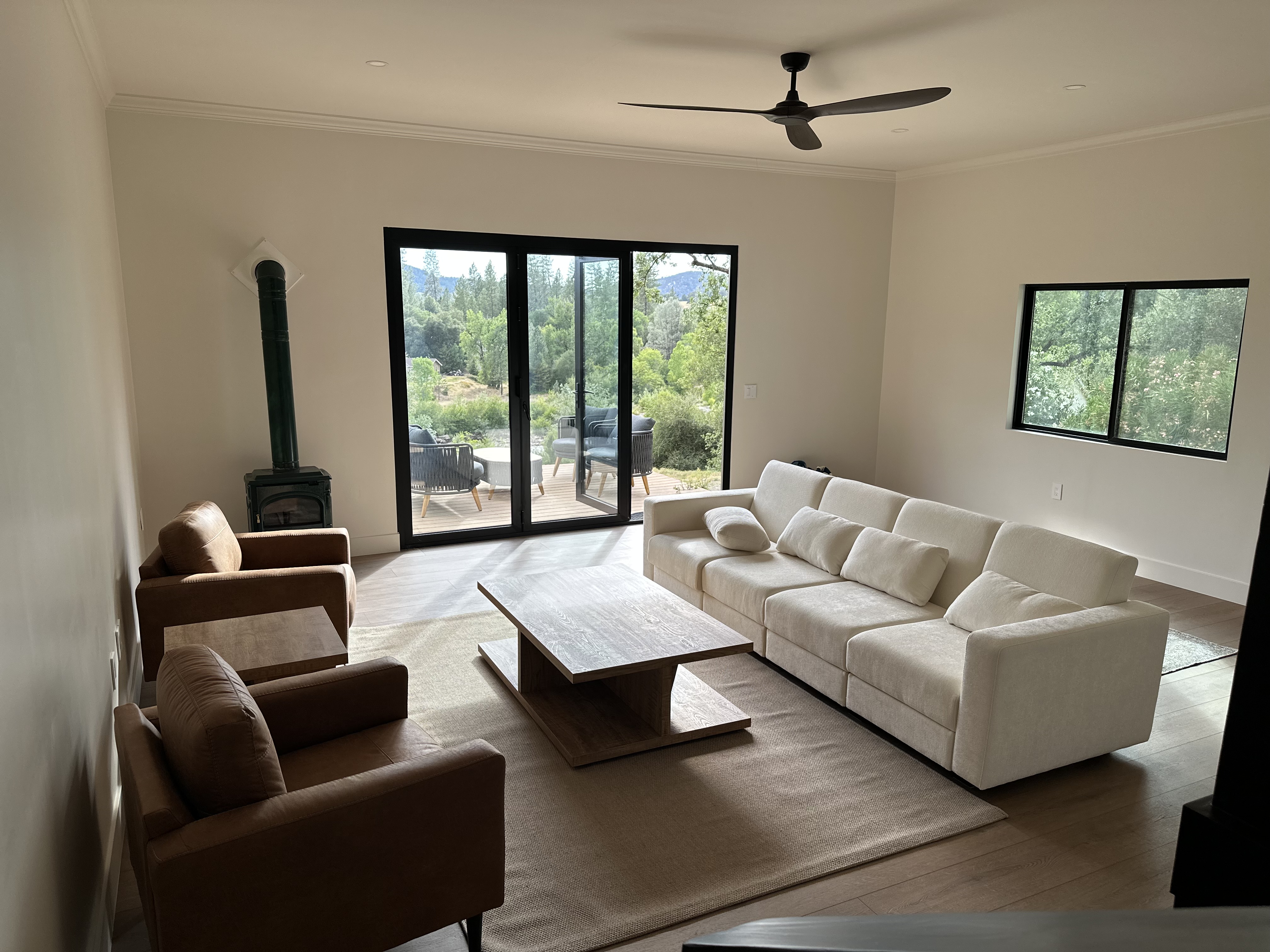Living room with gas stove and folding glass doors to the deck